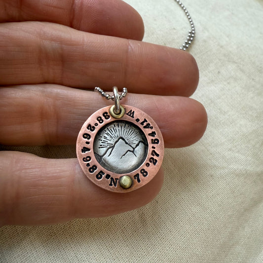 Personalized Mountain necklace with custom coordinates hand stamped on sterling silver and copper pendant. and golden brass rivet hand crafted by drake designs jewelry