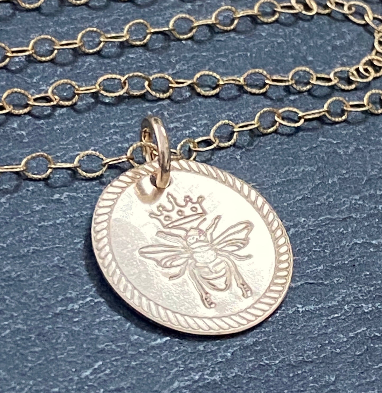 Queen Bee necklace. Rope edge border and bee with crown are hand stamped on 14k gold filled disc with a brushed finish. drake designs jewelry