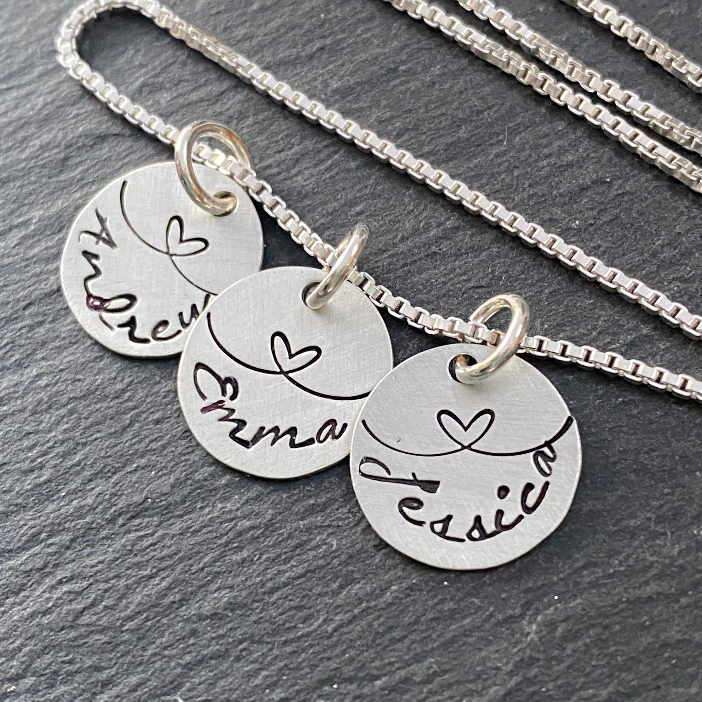mom necklace with kids names linked by love. sterling silver hand stamped charms with hearts. drake designs jewelry
