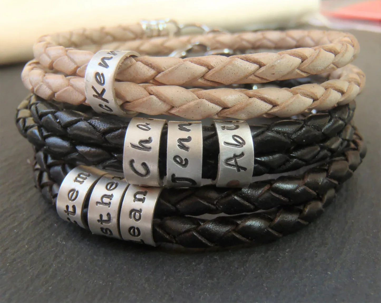 Personalized Leather Bracelets with kids names hand stamped on sterling silver hand riveted bead charms.