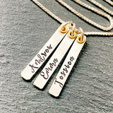 sterling silver mom necklace with kids names hand stamped on thick sterling silver bars and gold accent. drake designs jewelry