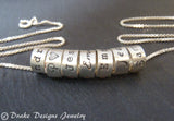 mom necklace with kids names on hand crafted sterling silver ring charms with your choice of font. drake designs jewelry