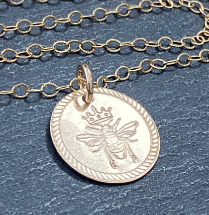 Queen Bee necklace. Rope edge border and bee with crown are hand stamped on 14k gold filled disc with a brushed finish.  drake designs jewelry