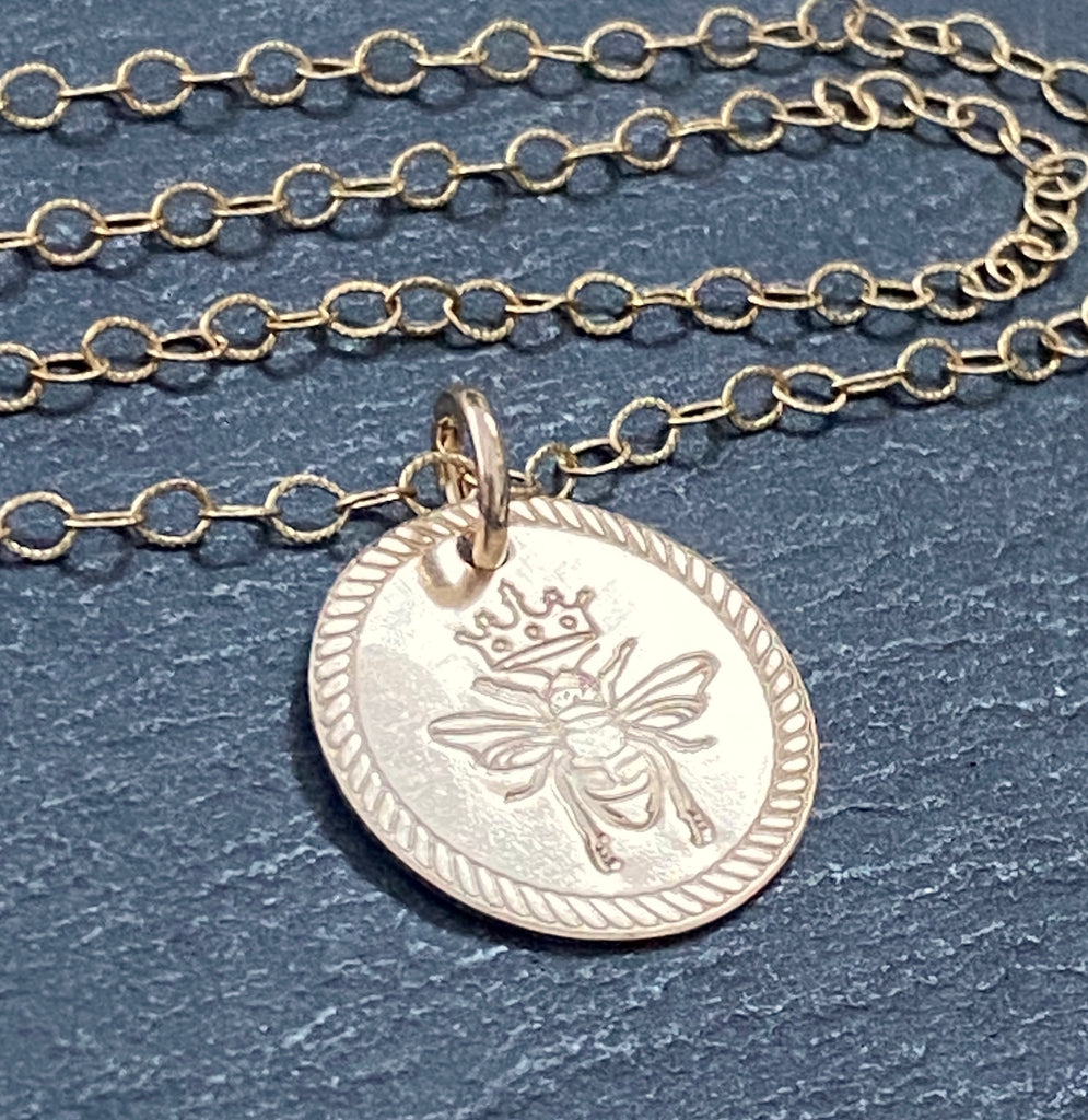 Queen Bee necklace. Rope edge border and bee with crown are hand stamped on 14k gold filled disc with a brushed finish.  drake designs jewelry
