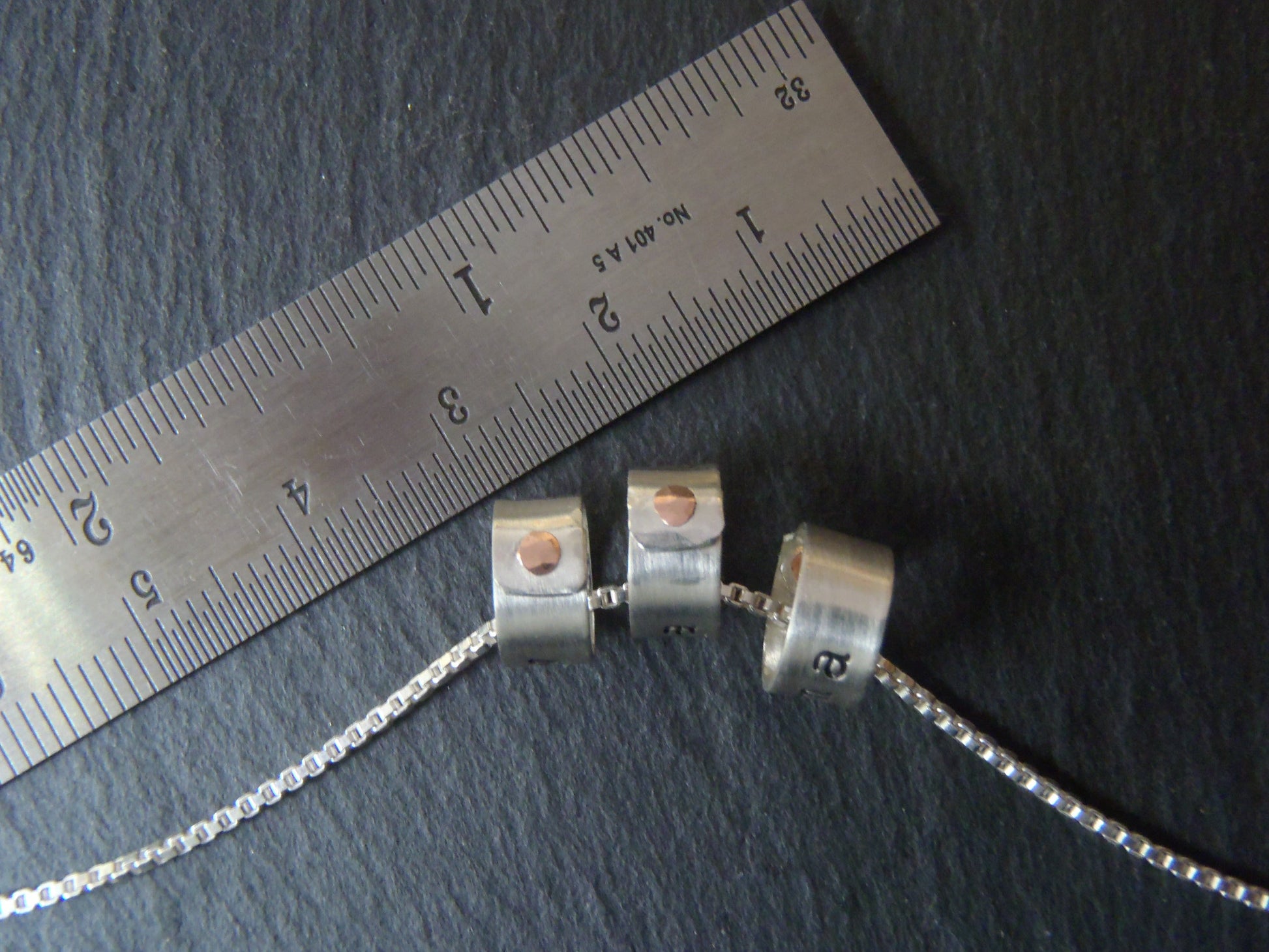 tiny sterling silver ring charms riveted with childrens names. drake designs jewelry