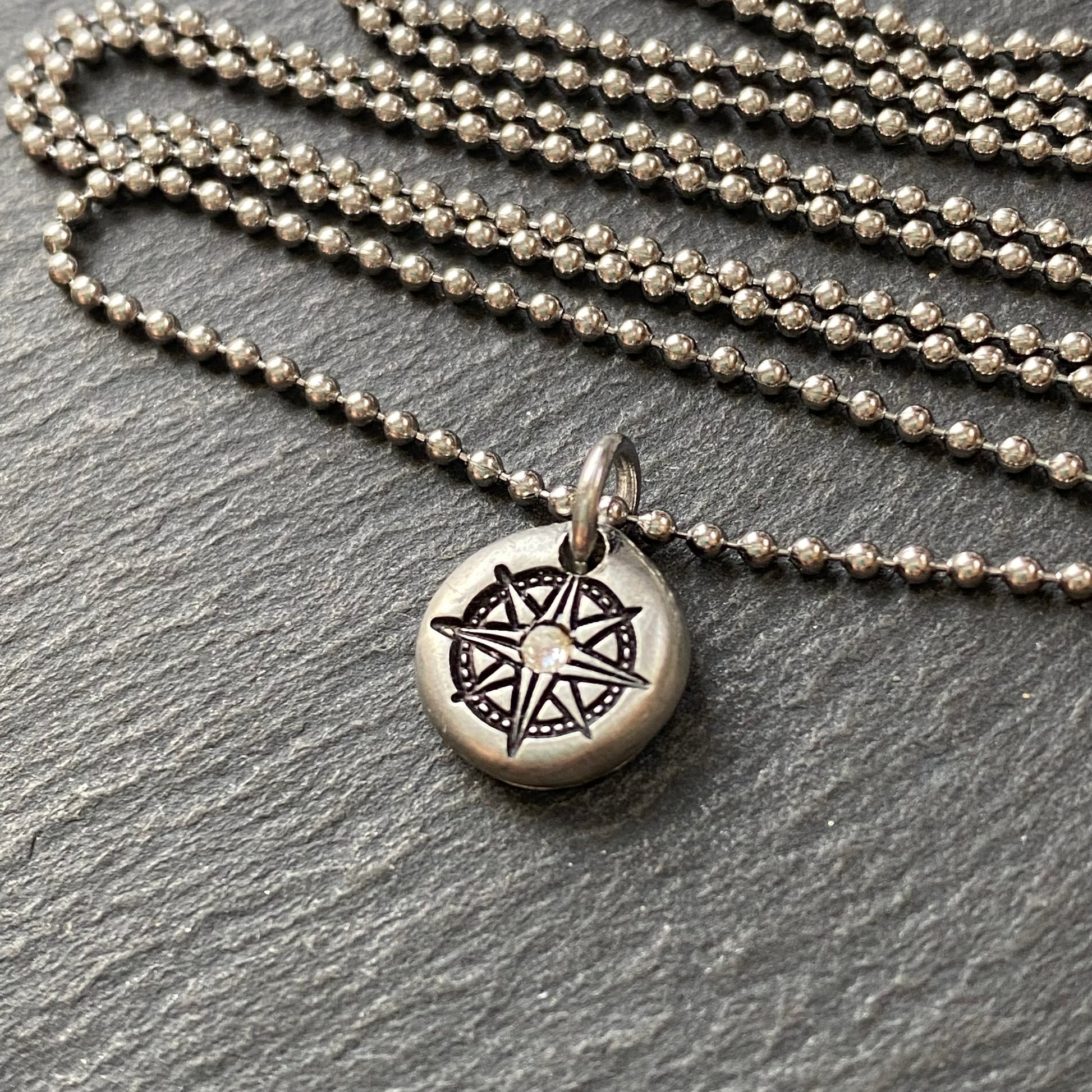 silver pebble compass necklace with hand set crystal at center - drake designs jewelry